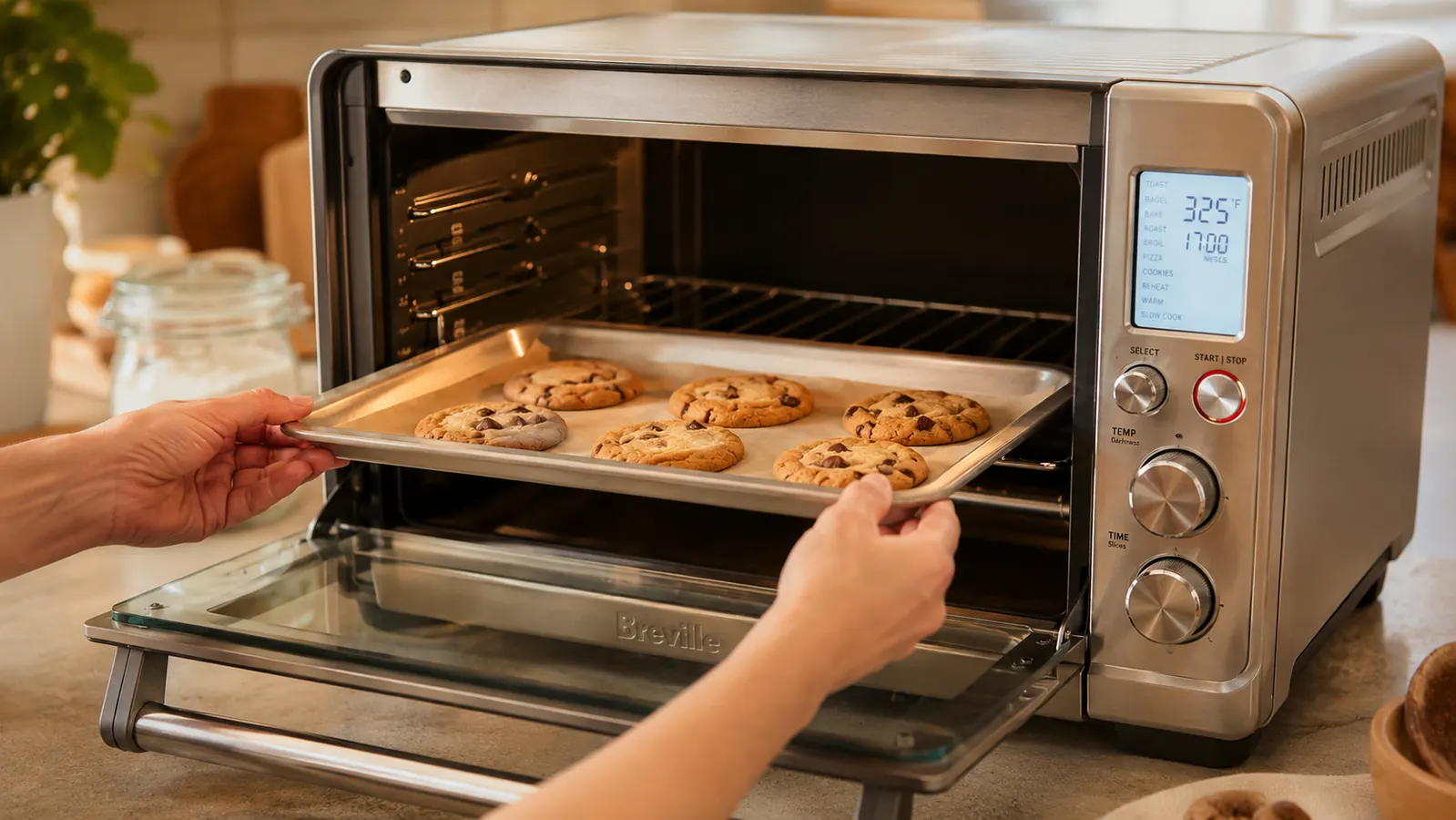 Hand placing a light-colored aluminum cookie sheet on the center rack inside the Breville Smart Oven Pro
