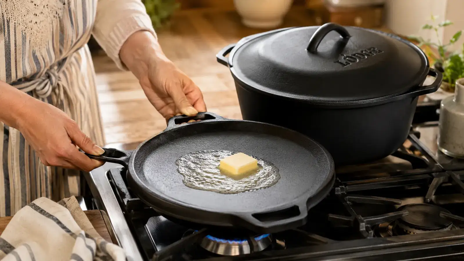 Lodge Double Dutch Oven lid used as a skillet with butter melting in it on a stovetop